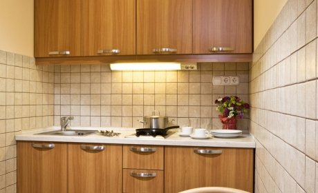 felszerelt konyha: hűtőszekrény, tűzhely és edények